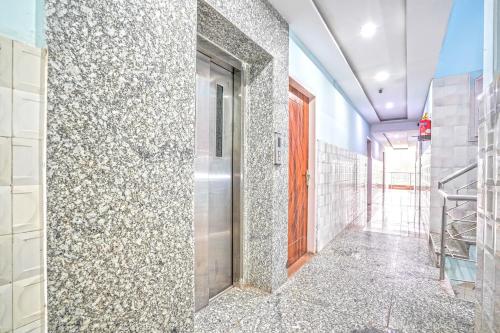 a hallway with a tile wall with a door at Super Hotel O Sector 52 Chandigarh Formerly Hari Residency in Chandīgarh