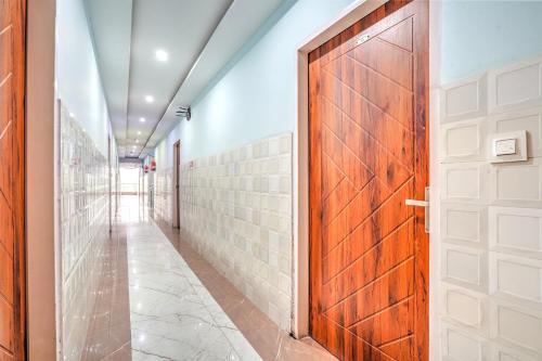a hallway with a wooden door and a tile wall at Super Hotel O Sector 52 Chandigarh Formerly Hari Residency in Chandīgarh