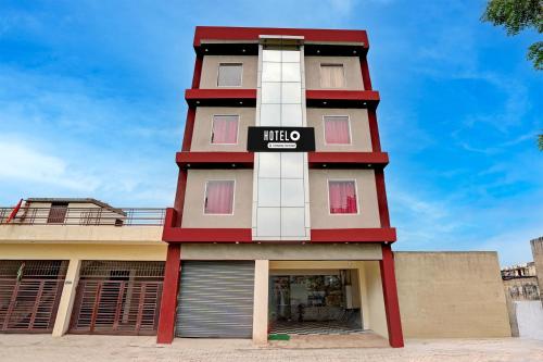 a tall red and white building with a sign on it at Super Hotel O Sector 52 Chandigarh Formerly Hari Residency in Chandīgarh