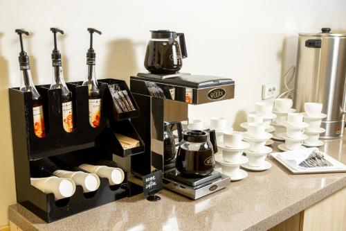 a coffee machine sitting on top of a counter with cups at INFINITY PLAZA BLOCK 1 in Atyraū