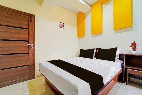 a bedroom with a bed next to a piano at Super Hotel O Dindugal Bus Terminal Formerly GK Building in Dindigul