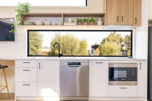 a kitchen with a sink and a window at Wairo Beach Holiday Park in Lake Tabourie