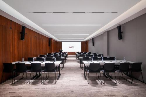 a room with rows of tables and chairs at Intercity Hotel Shantou CHJ in Shantou