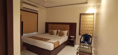a bedroom with a large bed and a blue chair at Hotel Hilltrip in Bānkura