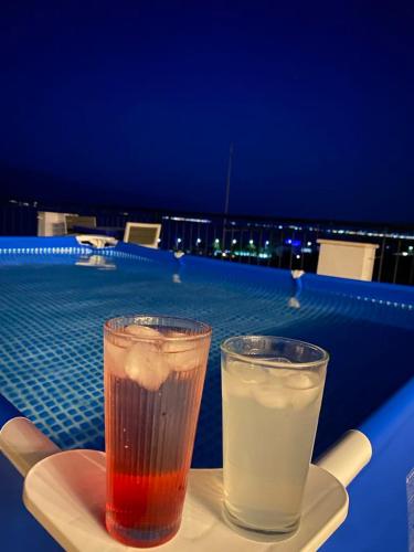 two drinks sitting on a plate next to a pool at Hotel Bar Restaurant Stone Dream in Udënisht