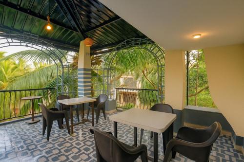 Un restaurante con mesas, sillas y ventanas. en Calangute Beach Home Away, en Calangute