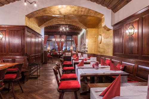 a restaurant with wooden tables and red chairs at Hotel Goldene Sonne in Landshut
