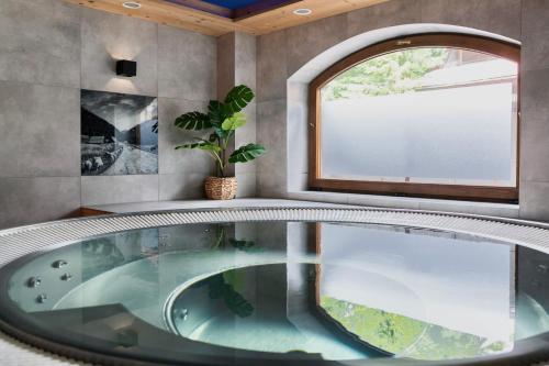 a bath tub in a room with a window at Willa Baciarka-basen, sauny i jacuzzi in Kościelisko