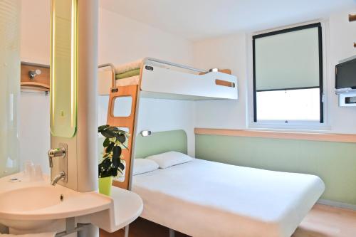 a small room with a bunk bed and a sink at ibis budget Saint-Quentin Centre Gare in Saint-Quentin