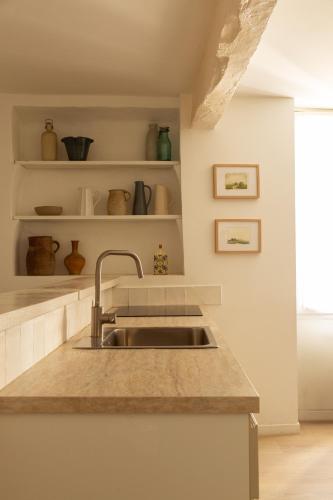 a kitchen with a sink and a counter at Maison de village Arty et terrasse au calme in Lourmarin