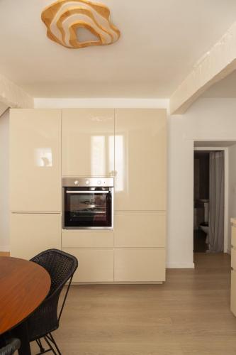 a kitchen with a table and a oven on the wall at Maison de village Arty et terrasse au calme in Lourmarin