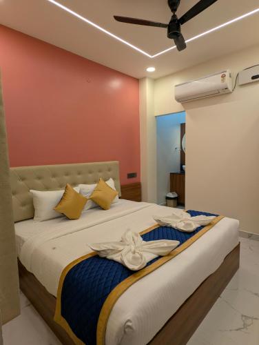 a bedroom with a large bed with a ceiling fan at VISAI Retreat in Tiruvannāmalai