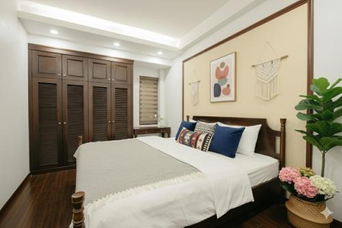 a bedroom with a large white bed with blue pillows at Lunaria Two Bedroom Apartment - The Epicenter of Luxury and Convenience in Hanoi