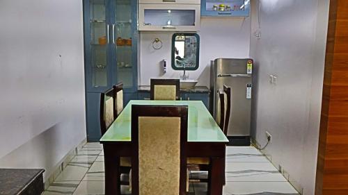 a dining room with a table and chairs and a refrigerator at Sindu Villa in Lucknow