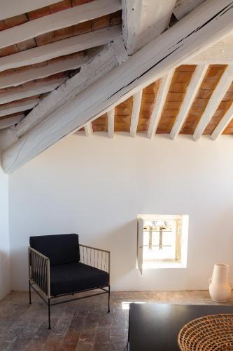 a living room with a black chair and a table at Maison de village Arty et terrasse au calme in Lourmarin