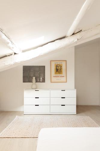 a white bedroom with a white dresser in a room at Maison de village Arty et terrasse au calme in Lourmarin