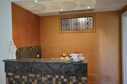 a bathroom with a marble counter and a window at RIAD Comfort Rooms in San Vito lo Capo