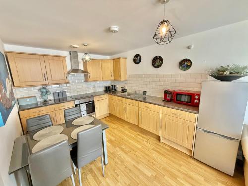 a kitchen with a table and chairs and a refrigerator at 15 min walk to Tower Bridge in London