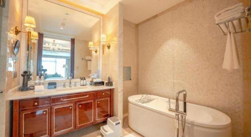 a bathroom with a tub and a toilet and a sink at Dongwu New Century Grand Hotel Huzhou in Huzhou