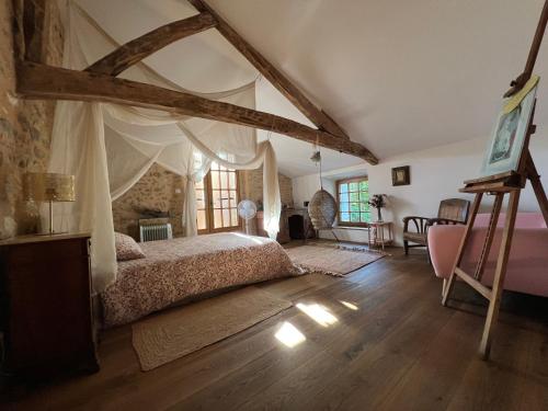 a bedroom with a bed with a canopy at Bel appartement dans Maison typique du Périgord in Rouffignac Saint-Cernin