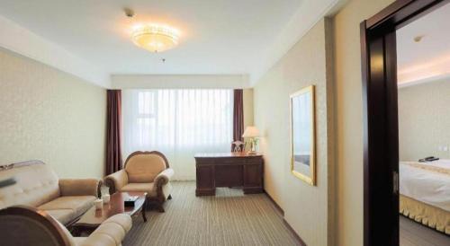 a hotel room with a bed and a living room at Yanji Yanbian International Hotel in Yanji