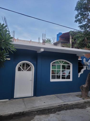 a blue building with a white door and two windows at Lirio Acuático in San Miguel