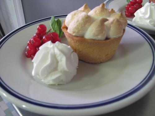 a plate with two cupcakes and whipped cream and berries at Albergo La Genzianella in Miasino