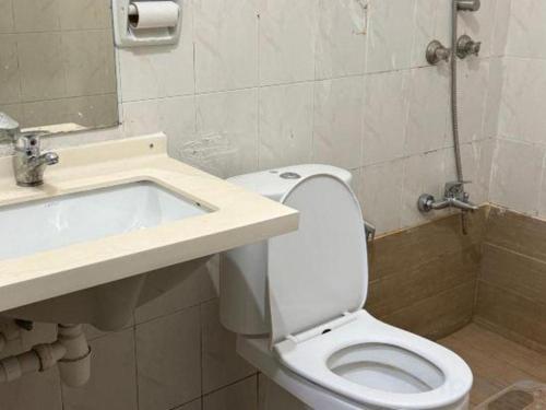 a bathroom with a white toilet and a sink at Lai Ming Hotel Cosmoland in Singapore