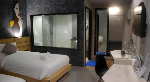 Un dormitorio con una cama, un escritorio y un espejo. en Hide & Seek Resort Krabi, en Ao Nang Beach
