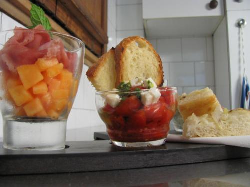 a tray with a sandwich and a bowl of fruit at Albergo La Genzianella in Miasino