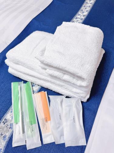 a pile of towels and towels on a table at Uhome Haneda Apartment in Tokyo
