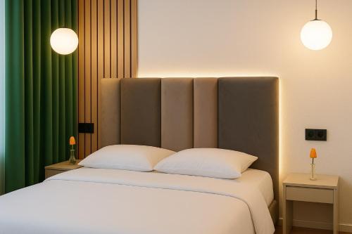 a bedroom with a white bed with two pillows at Double Room with Panoramic Lake View in Eforie Nord