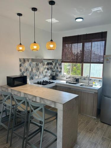 Una cocina con una gran isla con taburetes de bar. en Dunamar Beach House, en Los Órganos