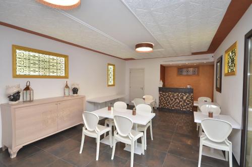 a dining room with white tables and white chairs at RIAD Comfort Rooms in San Vito lo Capo