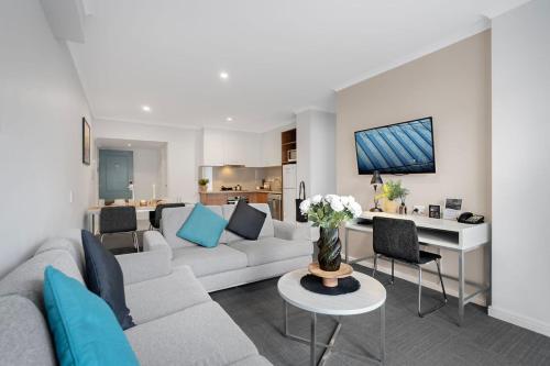 a living room with a couch and a table at Quest Mont Albert in Box Hill
