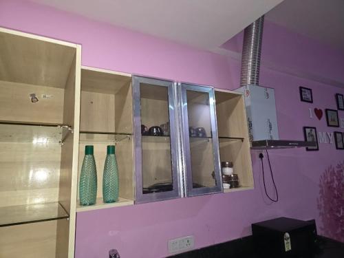 a purple room with vases sitting on a shelf at Singh Comfy Stay At Mall in Ghaziabad