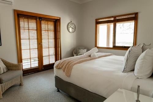 a bedroom with a bed and a clock on the wall at Chez Vous Villas Pokolbin in Pokolbin