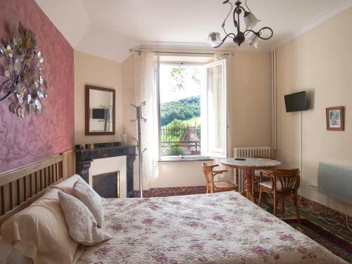 a bedroom with a bed and a fireplace and a window at Au Petit Verger in Puivert