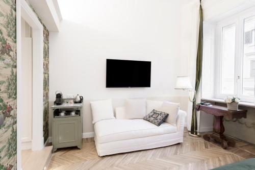 a living room with a white couch and a tv at Relais Donna Lucrezia in Rome