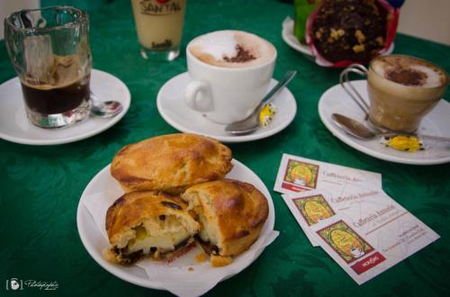 a table with plates of food and cups of coffee at Rescio's Rooms in Cavallino di Lecce