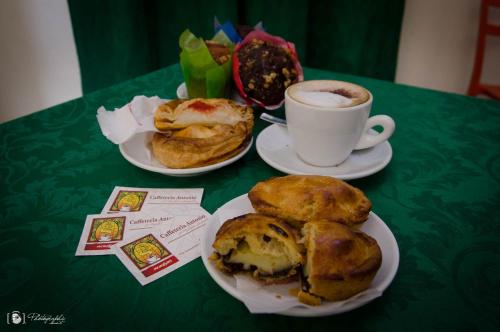 a table with two plates of pastries and a cup of coffee at Rescio's Rooms in Cavallino di Lecce