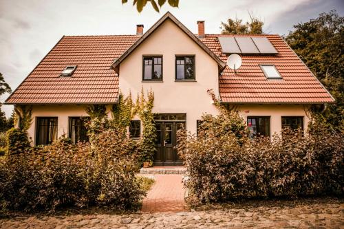 una casa con paneles solares en el techo en Designer Apartment In Historic Pond House, en Freudenfeld