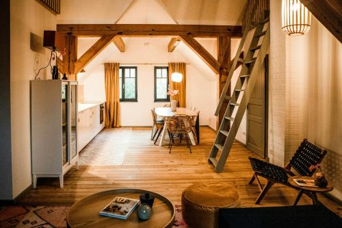 sala de estar con mesa y escalera en Designer Apartment In Historic Pond House, en Freudenfeld