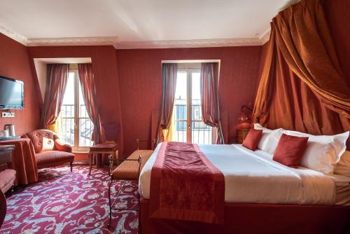 a hotel room with a large bed with red walls at La Villa Royale in Paris