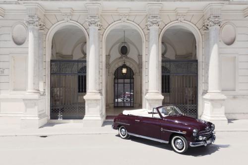 un viejo coche rojo estacionado frente a un edificio en Relais Donna Lucrezia, en Roma