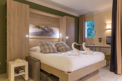 a bedroom with a bed with swans on it at Residence Pierre & Vacances Les Embruns in Deauville