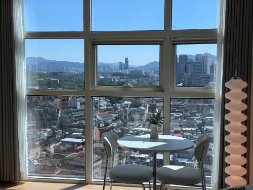 a table and chairs in a room with a large window at Seoul Station Studio-City View in Seoul