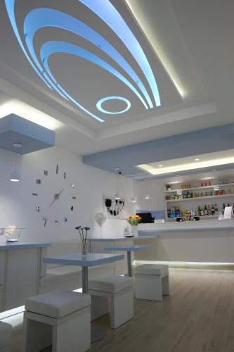 a kitchen with a blue ceiling with a table and benches at Hotel Perla Gaia in San Vito lo Capo