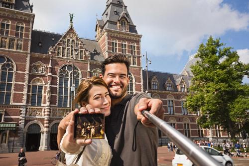 a man and a woman taking a picture in front of a building at The Highlander Amsterdam in Amsterdam