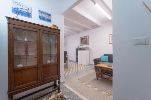 a living room with a wooden cabinet and a couch at Bene Ennidhos House - Alghero centro storico in Alghero